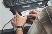 Ein Mann mit einer Sehbeeinträchtigung nutzt einen Screenreader am Computer.