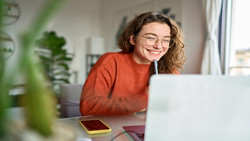 Das Bild zeigt ein fröhliche Person hinter einem Laptop