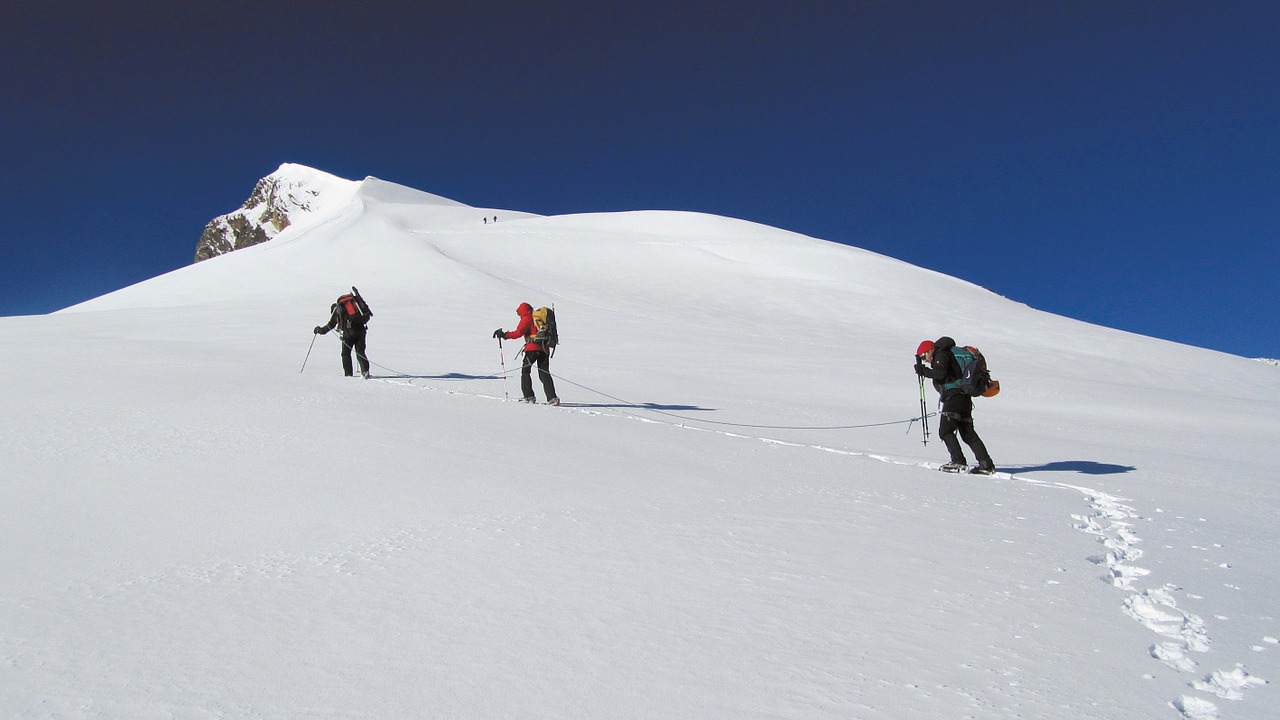 Wanderer besteigen einen verschneiten Gipfel