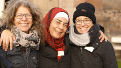 Das Bild zeigt drei glückliche Frauen unterschiedlicher Herkunft.
