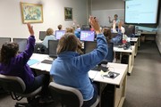 Menschen an PCs in einem Klassenraum