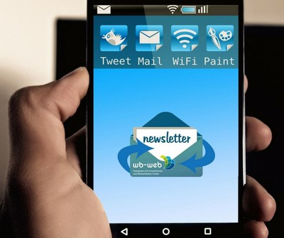 Das Display eines Handys mit einem Newsletter-Icon, einem Briefumschlag. Da drauf ist ein wb-web-Logo