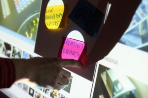 Das Bild zeigt einen vergrößerten Computerbildschirm und eine Hand, die daraufzeigt.
