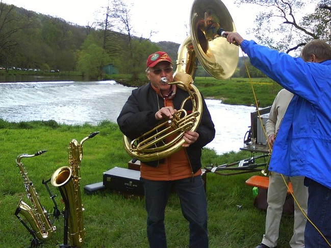 Ein Mann spielt Tuba, ein zweiter Mann hält ein Mikro in die Tuba  