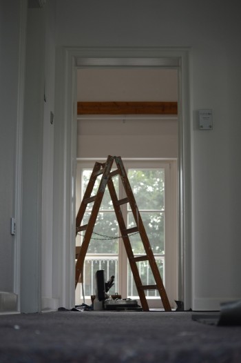 Eine Leiter und Malersachen stehen in einer Wohnung